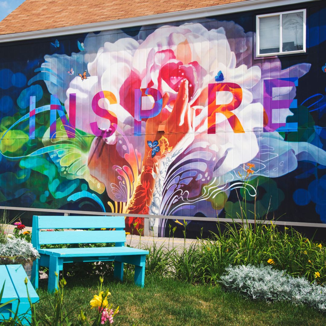 A colourful abstract image on the side of a house, with the word inspire creatively put within the image.