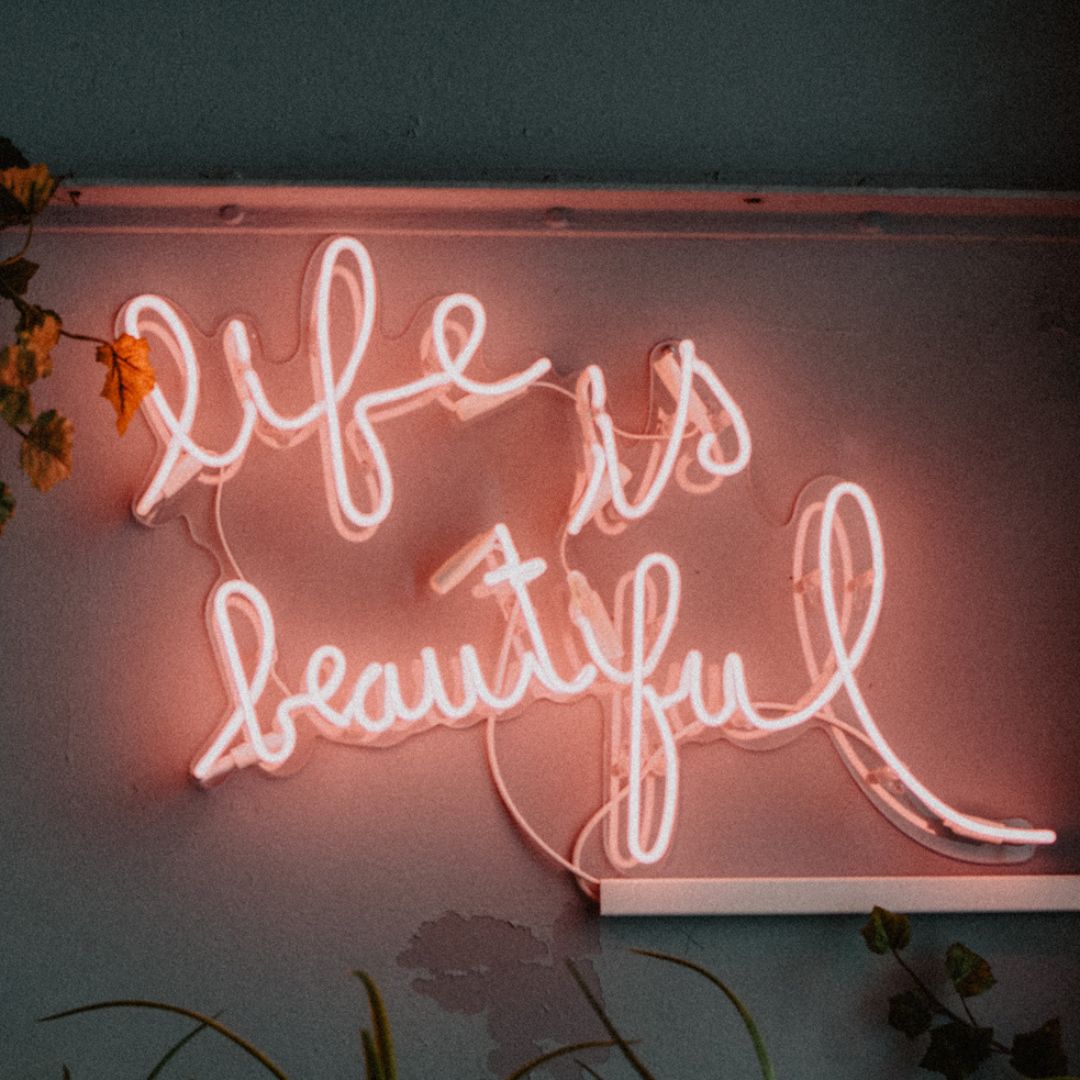 A neon pink sign beautifully crafted to show the words life is beautiful.
